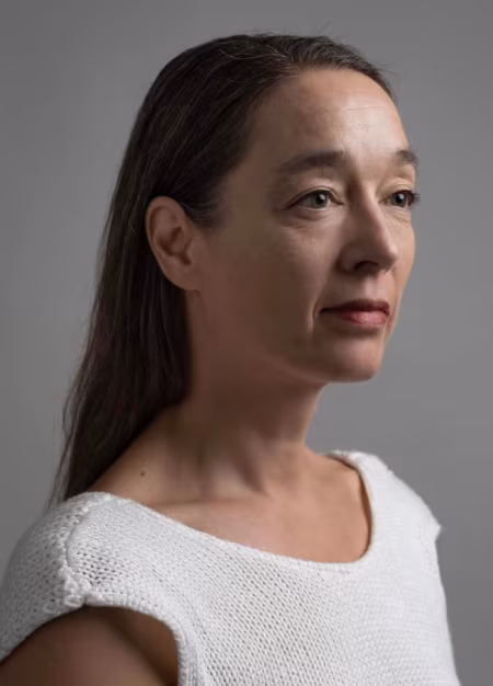Professioneel portret van betsy torenbos met lange haren en witte gebreide trui op grijze achtergrond