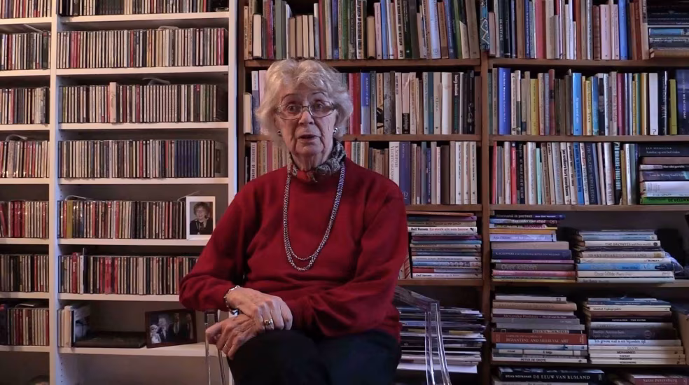 Oude lezer in privé bibliotheek met boekenkasten vol boeken, cd's en tijdschriften - interview setting stichting be-wonder